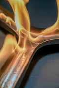 A close-up image of a fire starter device with a flame emerging from it, indicating the product is used to start fires.